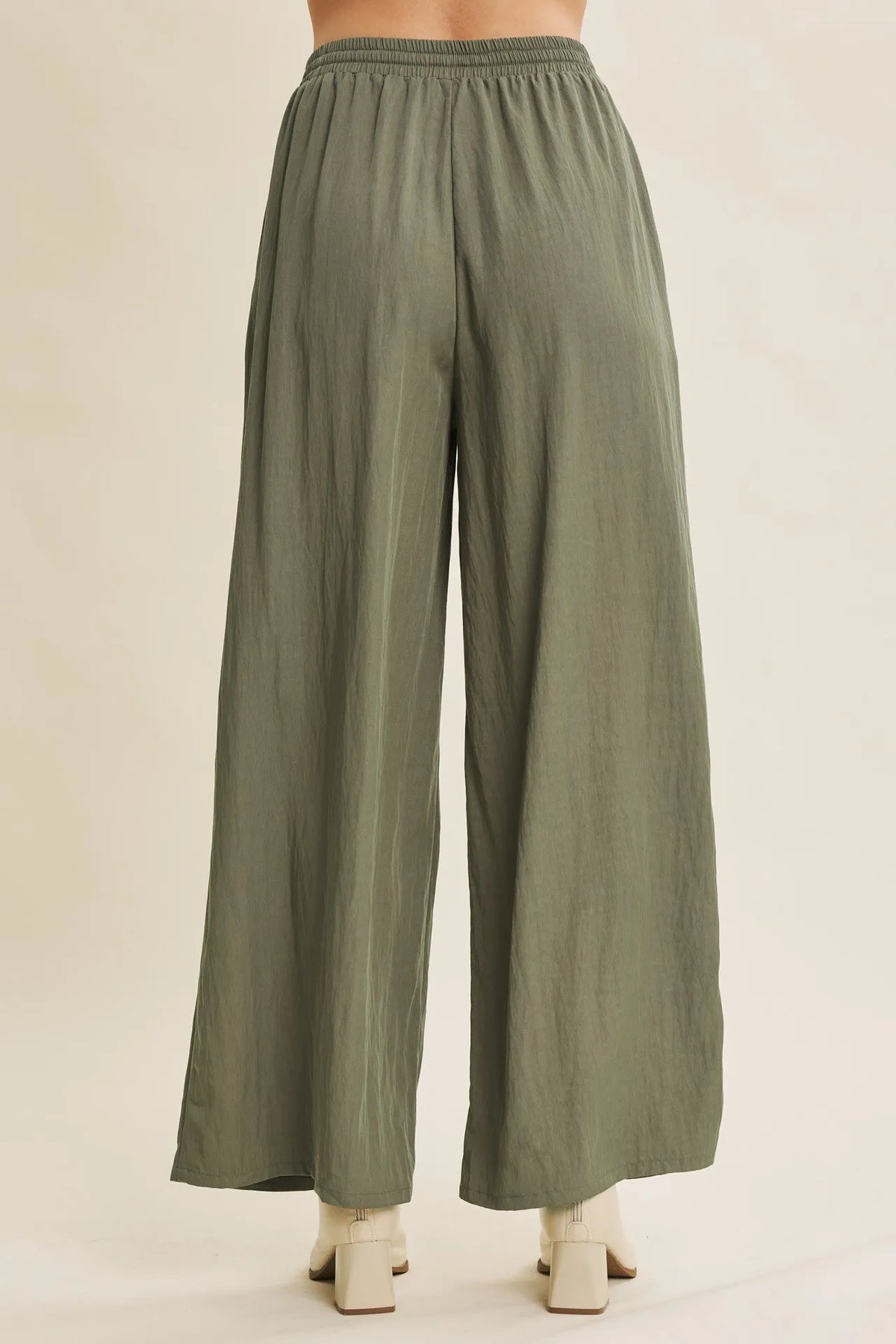 Olive green wide leg pants with elastic waistband featuring a step washed finish for a casual look
