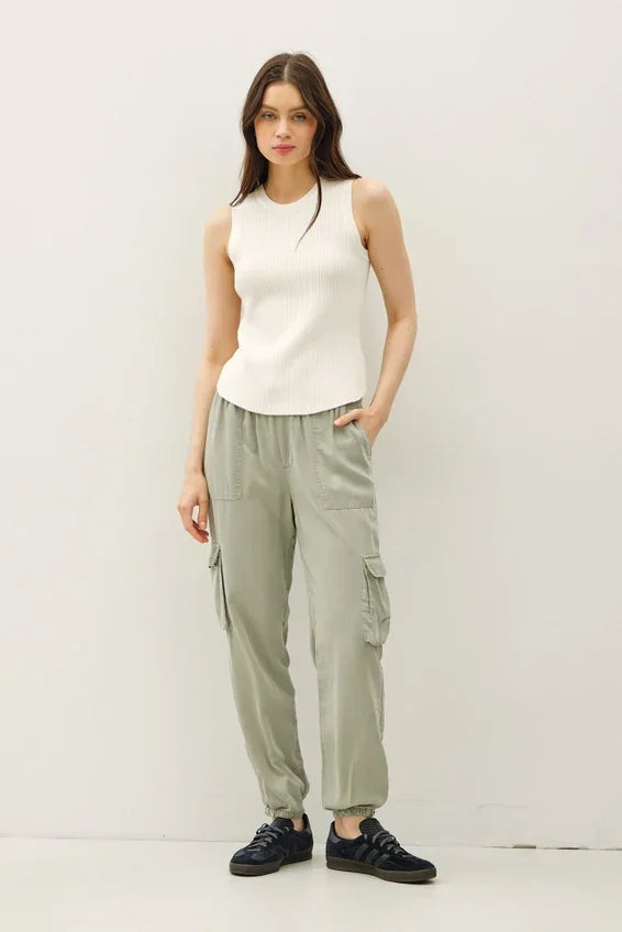 Olive green cargo pants with elastic cuffs and pockets, paired with fitted ribbed tank top