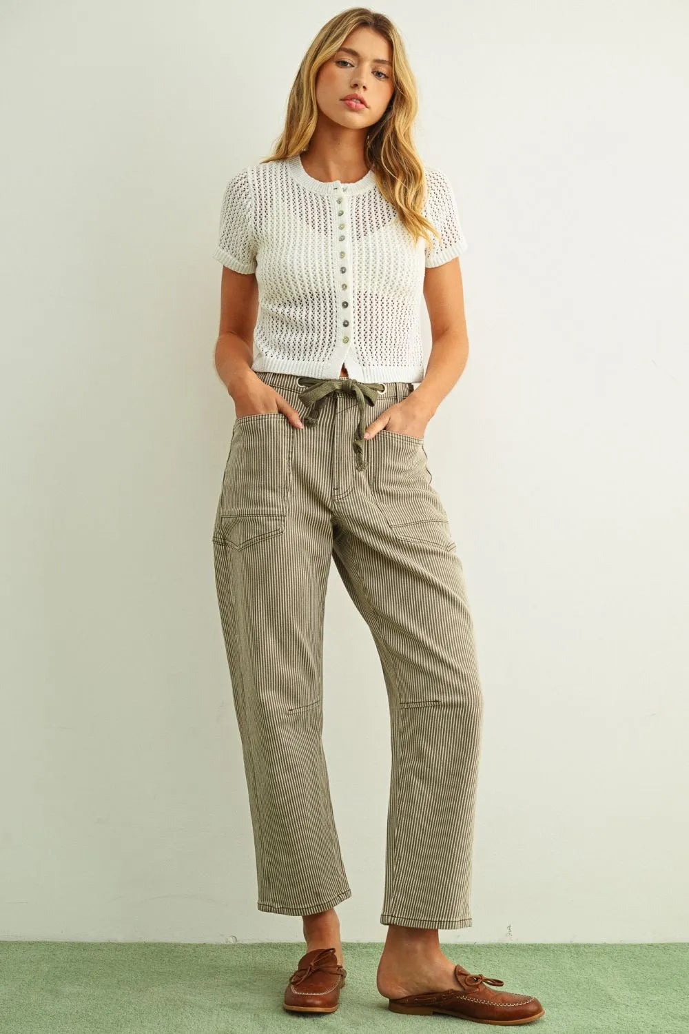 A pair of olive and white cargo pants with drawstring waistband complementing a short sleeve knitted top