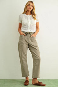 A pair of olive and white cargo pants with drawstring waistband complementing a short sleeve knitted top