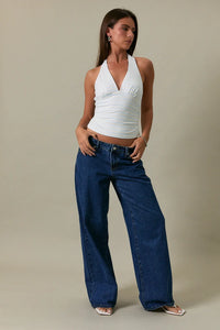 A pair of wide-leg blue denim jeans with classic five-pocket design complementing a double stripe halter neck top