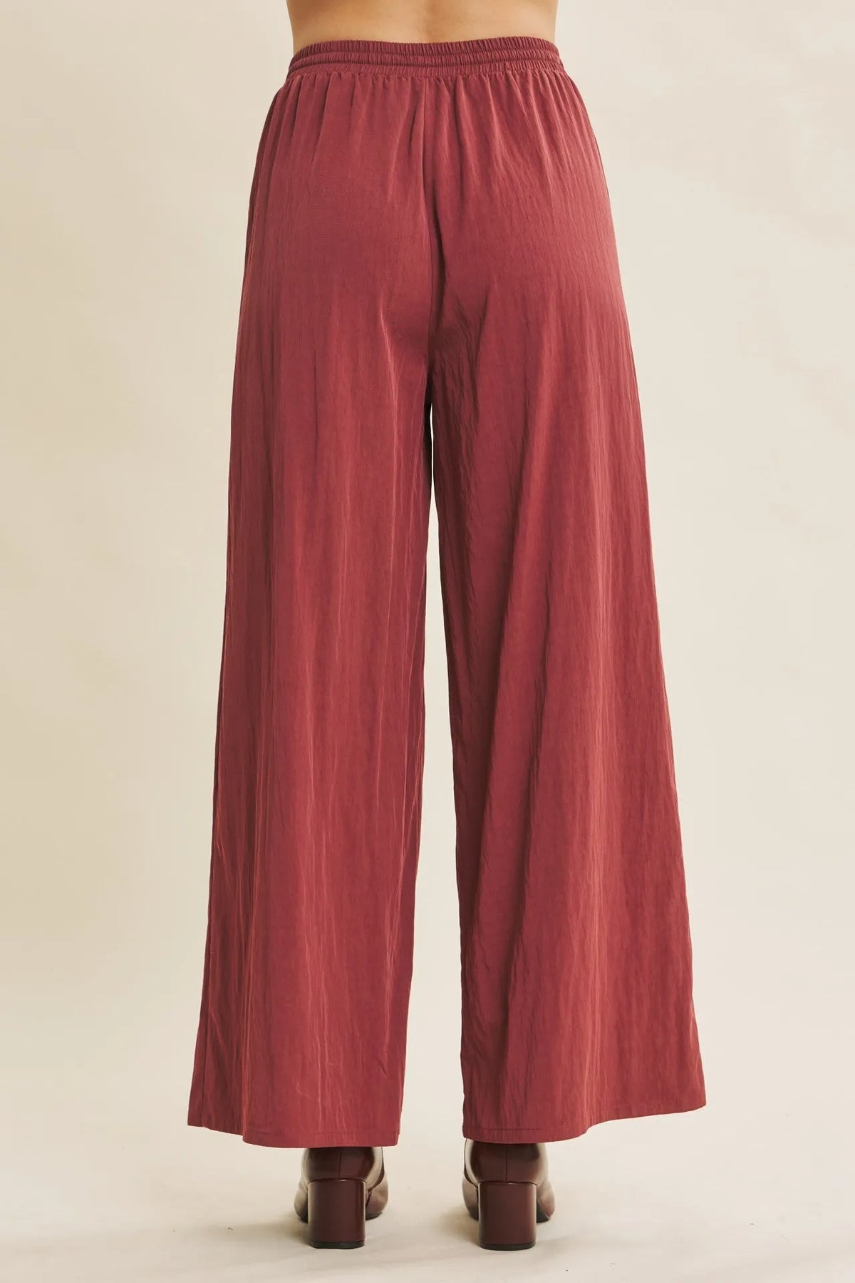 A pair of rust-colored every step washed look wide leg pants in flowing lightweight fabric with elastic waistband