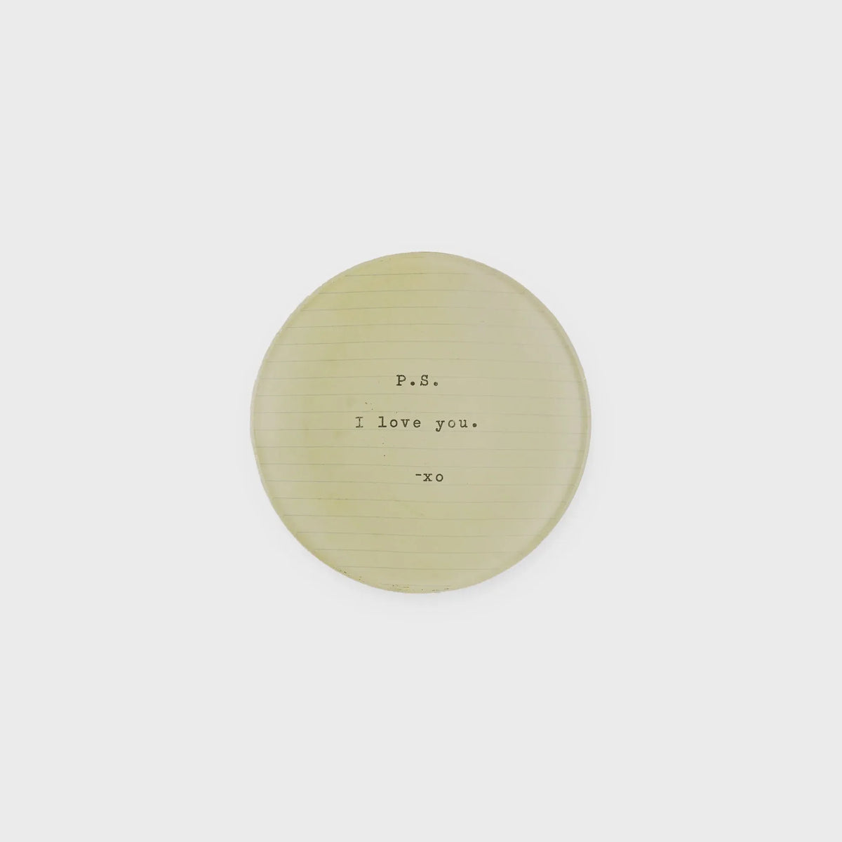 A pale yellow round plate with a subtle textured surface and typewritten text p.s. in shop daisy collection