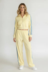 A pale yellow landon track cropped jacket with blue vertical stripes paired with matching track pocket side double line pants