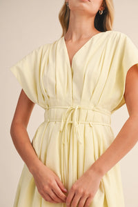 A pale yellow poplin short sleeve belted maxi dress with v-neckline and flutter sleeves featuring pleated detail