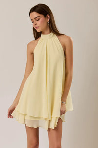 A flowing pale yellow halter neck ruffle chiffon mini dress with a tiered ruffle hem perfect for summer wear