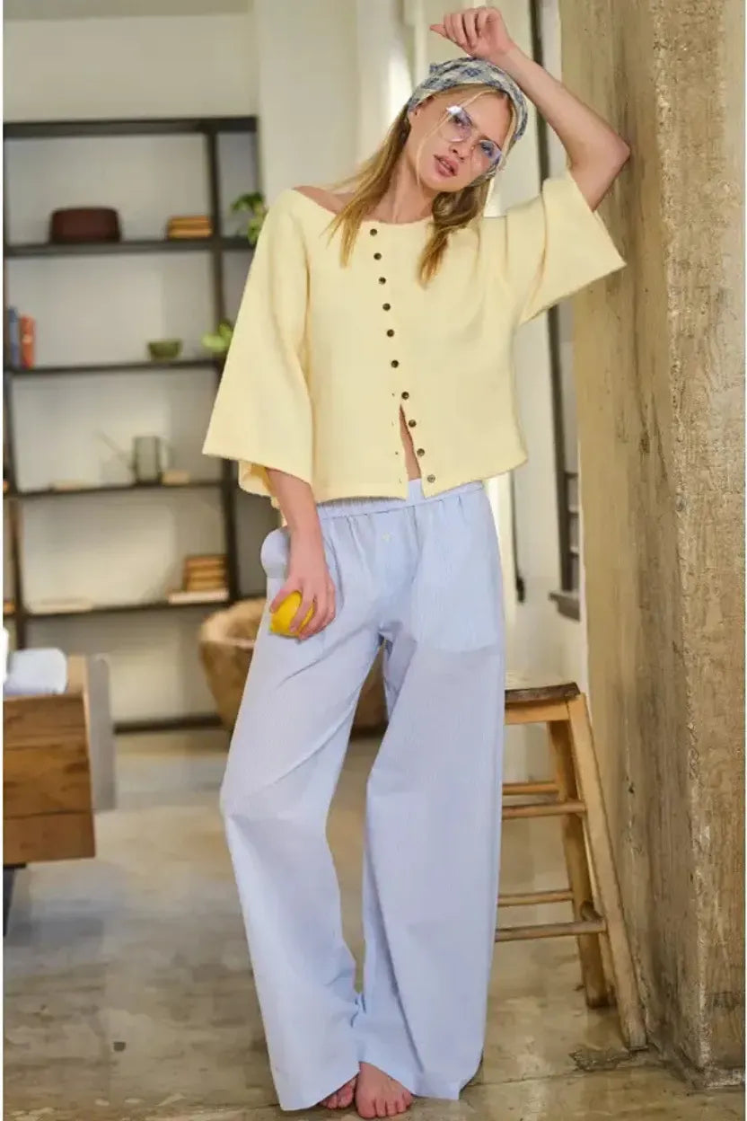 Pale yellow wide sleeve button front cardigan knit fabric with off-the-shoulder neckline and dark brown buttons