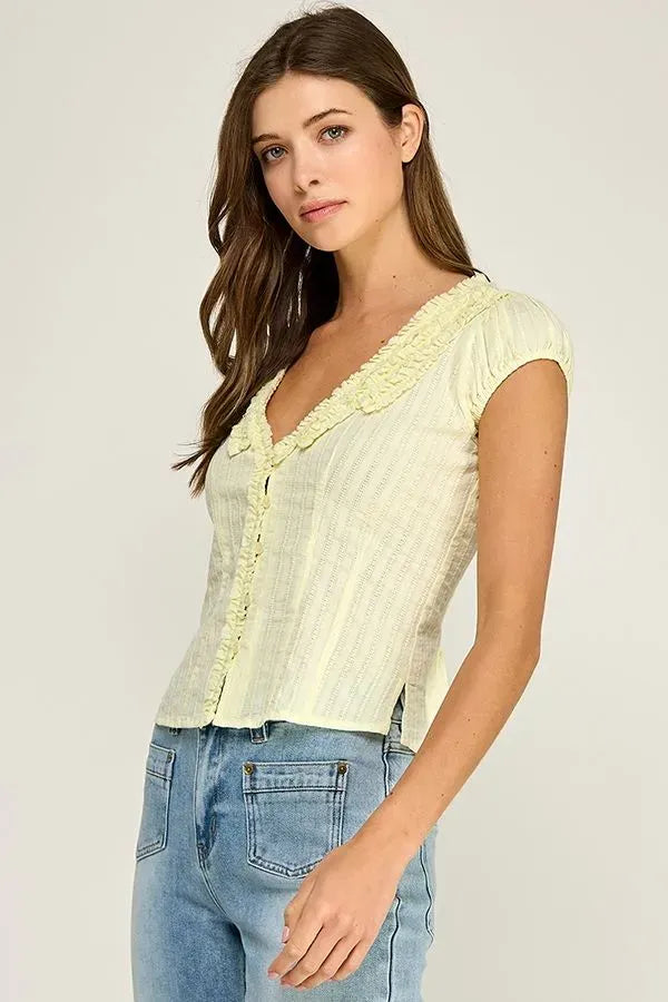 Pale yellow short-sleeved ruffle trim v-neck blouse with ruffled neckline and vertical ribbed texture