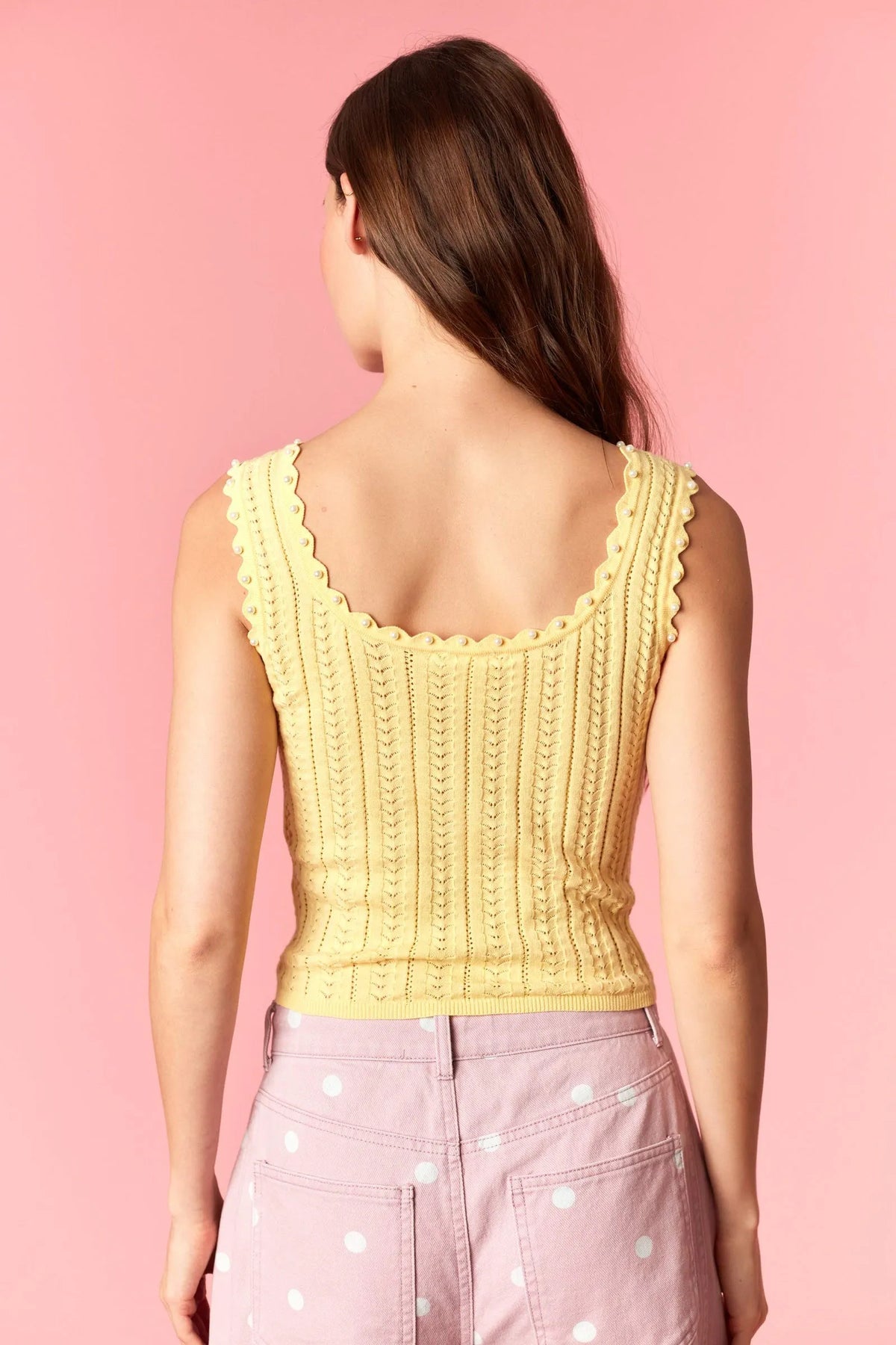 Pale yellow sleeveless knitted crop top with scalloped neckline and vertical ribbed texture pearl studs knit tank