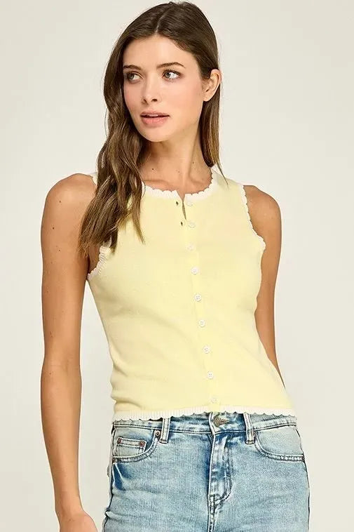 A pale yellow sleeveless scallop trim knit top with white buttons down the front and scalloped edges