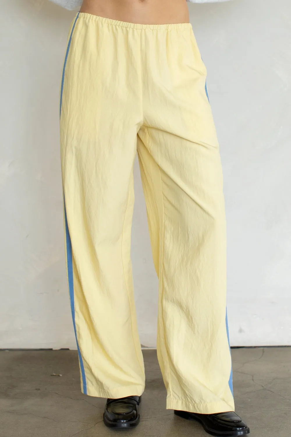Pale yellow landon track pocket double line pants with wide legs and subtle blue vertical stripe on side seam