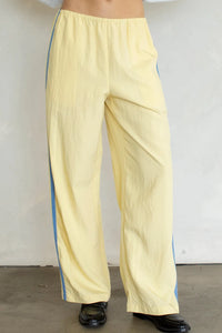 Pale yellow landon track pocket double line pants with wide legs and subtle blue vertical stripe on side seam