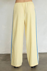 Pale yellow landon track double line pants with light blue vertical stripes and side pockets in wide-leg design