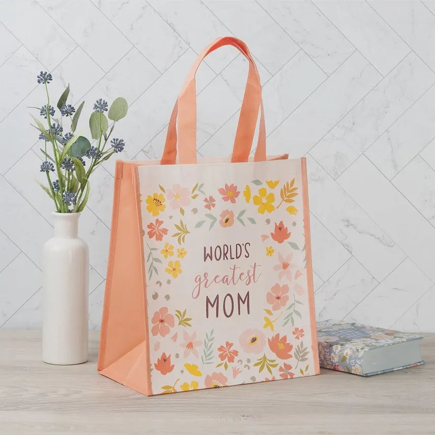 A peach floral print reusable tote bag featuring the text world’s greatest mom in black cursive script