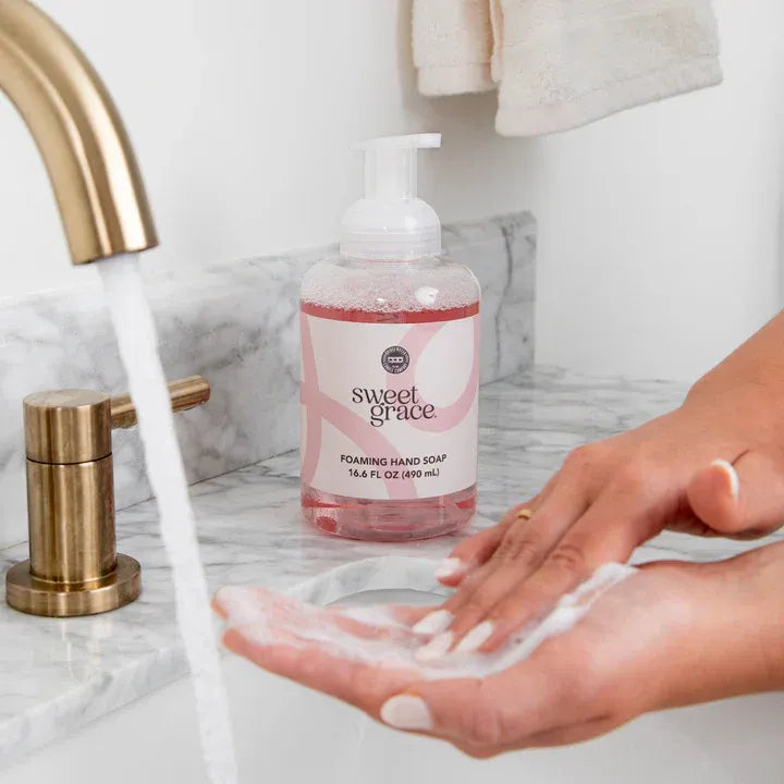 A pink sweet grace foaming hand soap bottle with a white pump and minimalist label for gentle hand cleaning