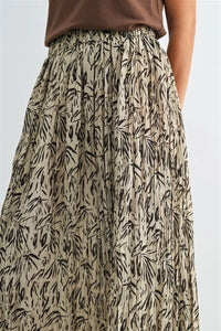 A flowing beige crinkle leaf print midi skirt with black bamboo leaf print and pleated design