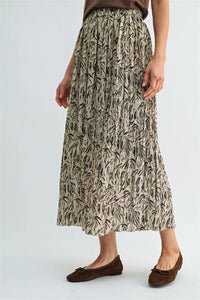 A beige crinkle leaf print midi skirt featuring flowing pleats and black leafy patterns for elegant wear
