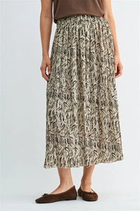 A flowing beige crinkle leaf print midi skirt with black leaf patterns in pleated design