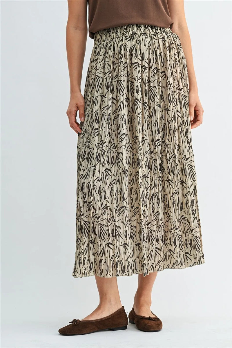 A flowing beige crinkle leaf print midi skirt with black leaf patterns in pleated design
