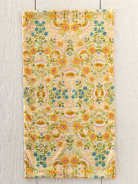 A boho bandeau headband with taupe mandala design featuring a soft textured towel floral pattern in yellow blue and green