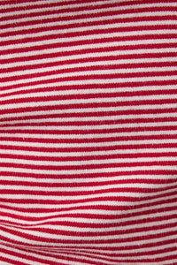 Close-up of red and white knit fabric of contrasted striped tank top featuring horizontal stripes in soft material