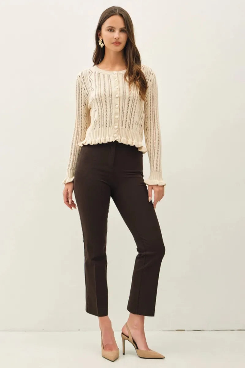 Cream-colored ruffled pointelle crop cardigan with long sleeves ribbed knit texture and button closure