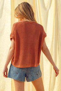 Rust-colored ribbed knit short-sleeved dolman sleeve knitted top with relaxed fit and soft texture