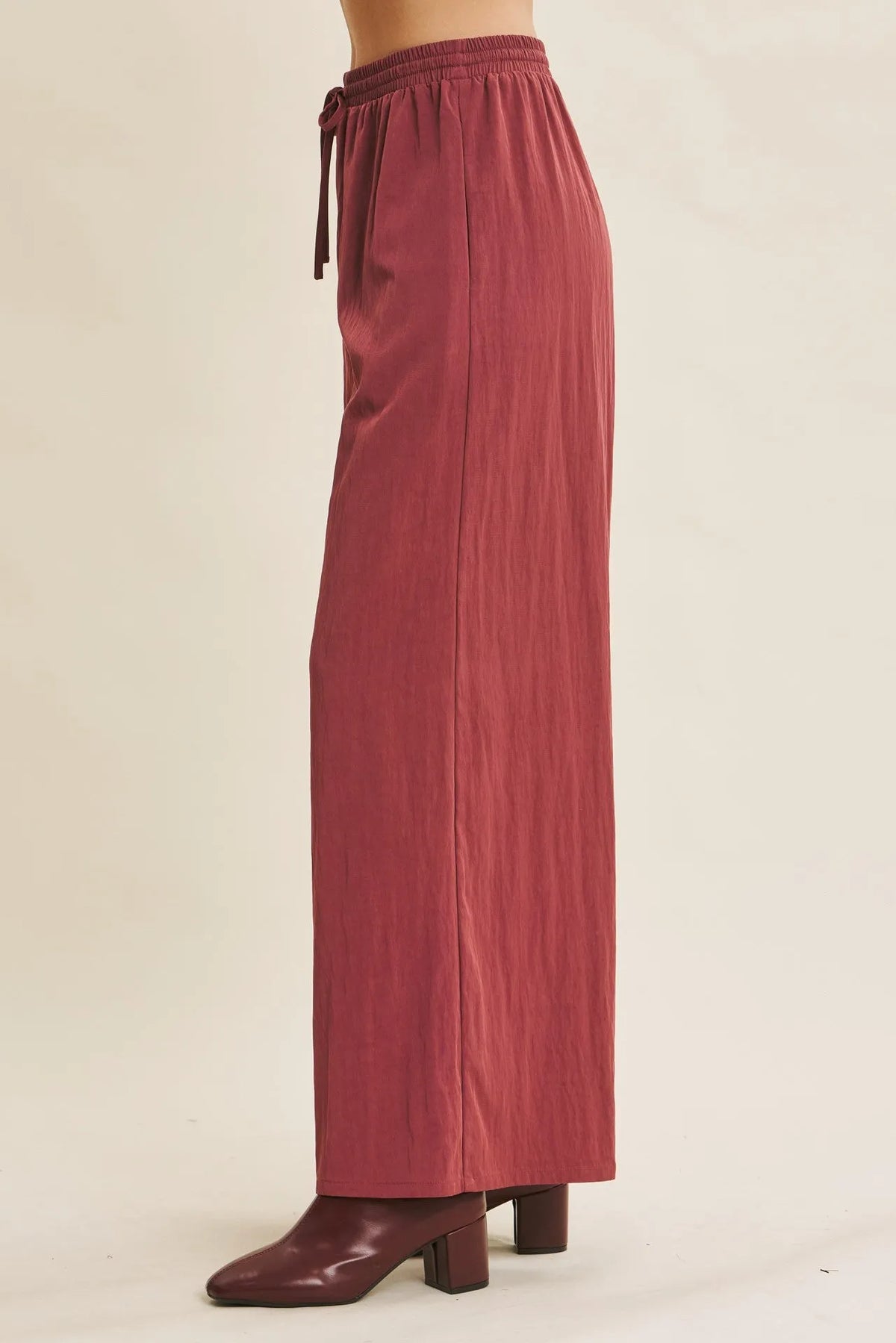 Rust-colored wide leg pants with elastic waistband and drawstring in a step washed fabric for comfortable wear