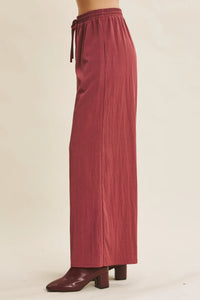 Rust-colored wide leg pants with elastic waistband and drawstring in a step washed fabric for comfortable wear