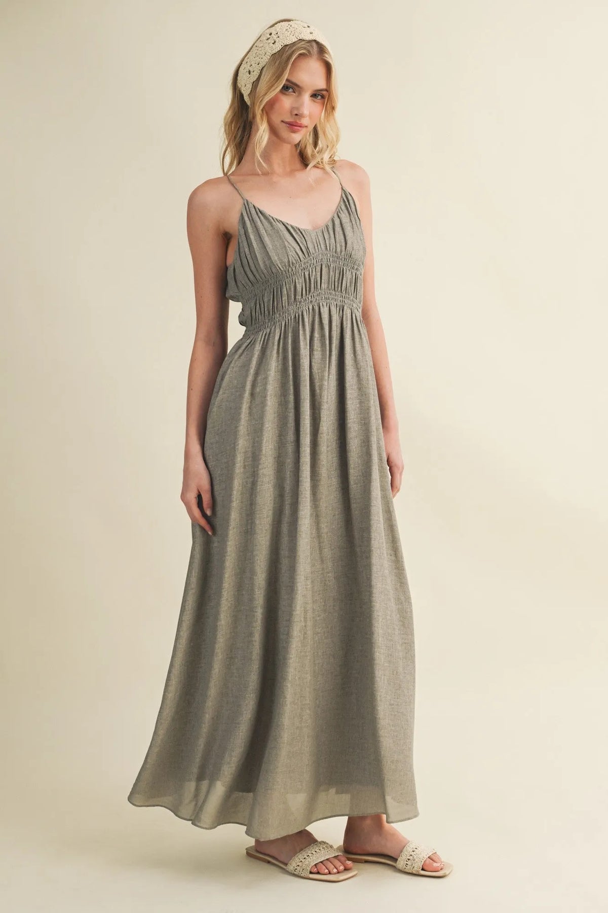 A flowing sage green maxi dress featuring a shirred bodice and delicate bodice spaghetti straps