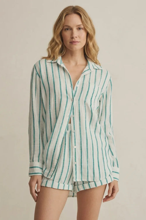 A woman wears a loose saturdays stripe button long-sleeved shirt with vertical green and white stripes