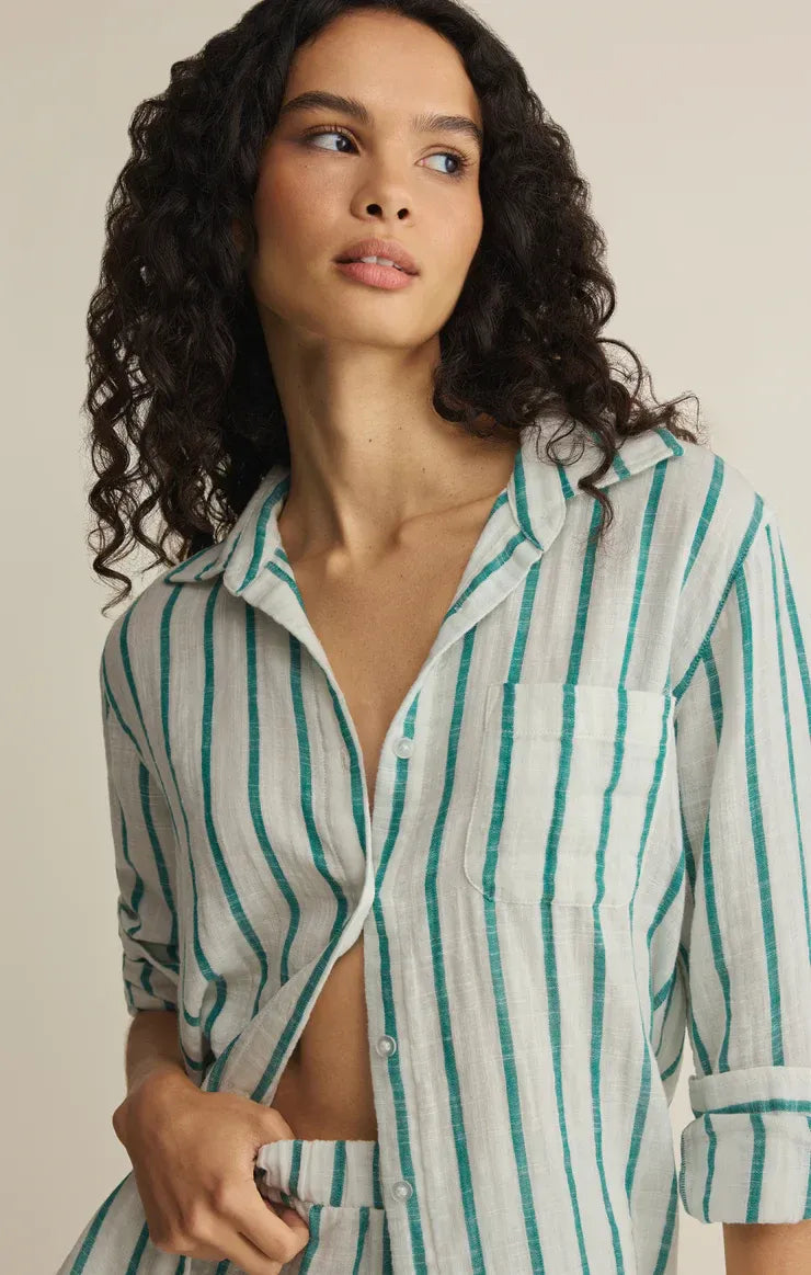 A woman wears a lightweight saturdays stripe button down shirt with green and white vertical stripes