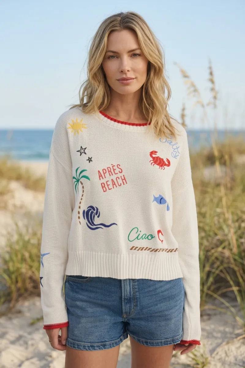 Off-white knit day sienna sweater with colorful embroidered beach motifs and red neckline and cuff trim