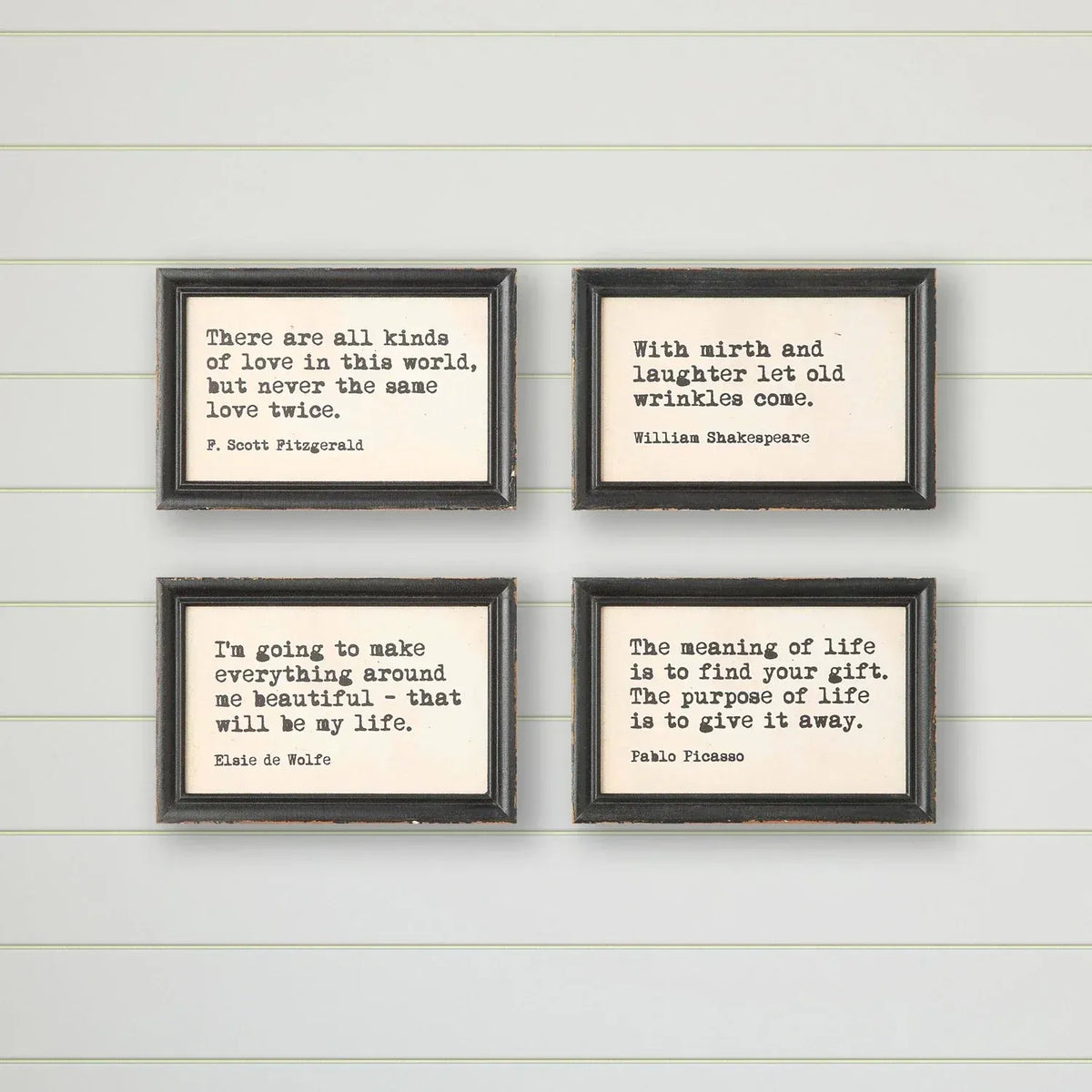 Set of four black-framed wood framed wall decor prints with typewriter style sayings for framed wall decor use
