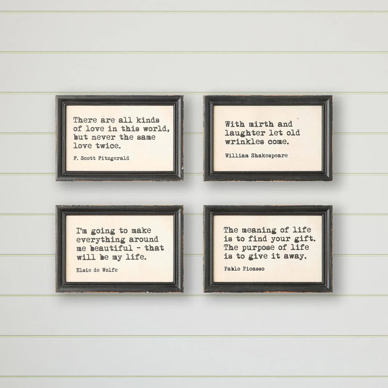Set of four black-framed wood framed wall decor prints with typewriter style sayings for framed wall decor use