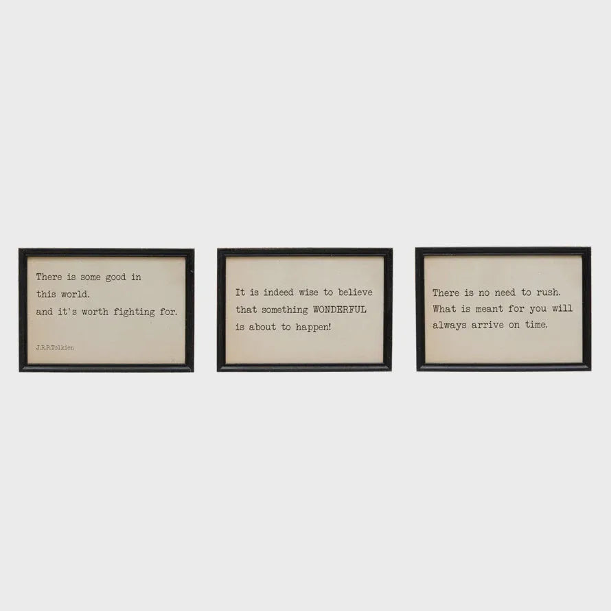 Set of three black-framed typewriter-style quote prints on cream paper in wood framed wall decor for framed wall display
