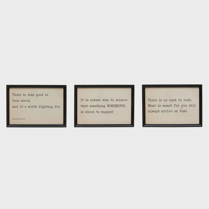 Set of three black-framed typewriter-style quote prints on cream paper in wood framed wall decor for framed wall display