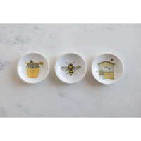 Set of three white ceramic bee-themed dishware pieces featuring honey jar, bee, and beehive illustrations for shop daisy