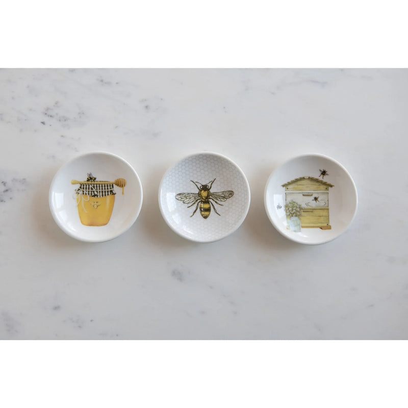 Set of three white ceramic bee-themed dishware pieces featuring honey jar, bee, and beehive illustrations for shop daisy