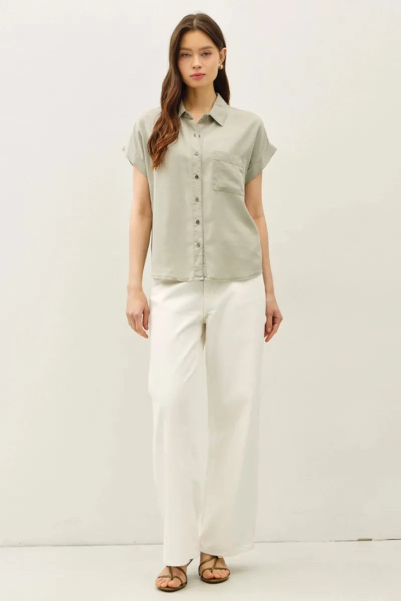 A light sage green short dolman sleeve button shirt with classic collar and front pocket for casual wear