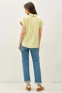 Pale yellow short dolman sleeve button shirt with classic collar and subtle back pleats shown from the back side