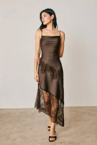 A sleek chocolate-brown satin slip dress with asymmetrical lace trim and delicate black lace detailing on hem and sides