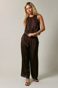 A sleek dark brown satin jumpsuit with elastic waist lace and delicate black lace trim along neckline and hem