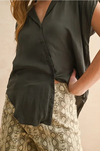 A sleek dark olive green silk lightweight button down cap sleeve shirt with a relaxed fit and button front