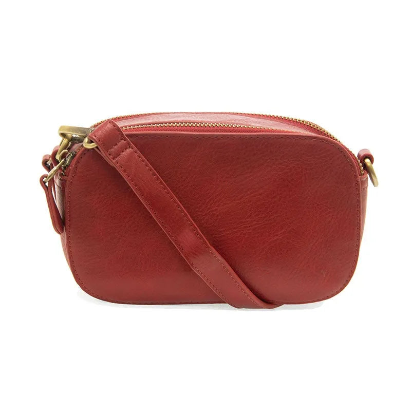 A sleek reddish-brown leather layne double zip mini crossbody bag with gold-toned zipper and hardware details