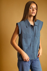 A sleek sleeveless blue chiffon blouse with collar two front pockets and button front design for stylish wear