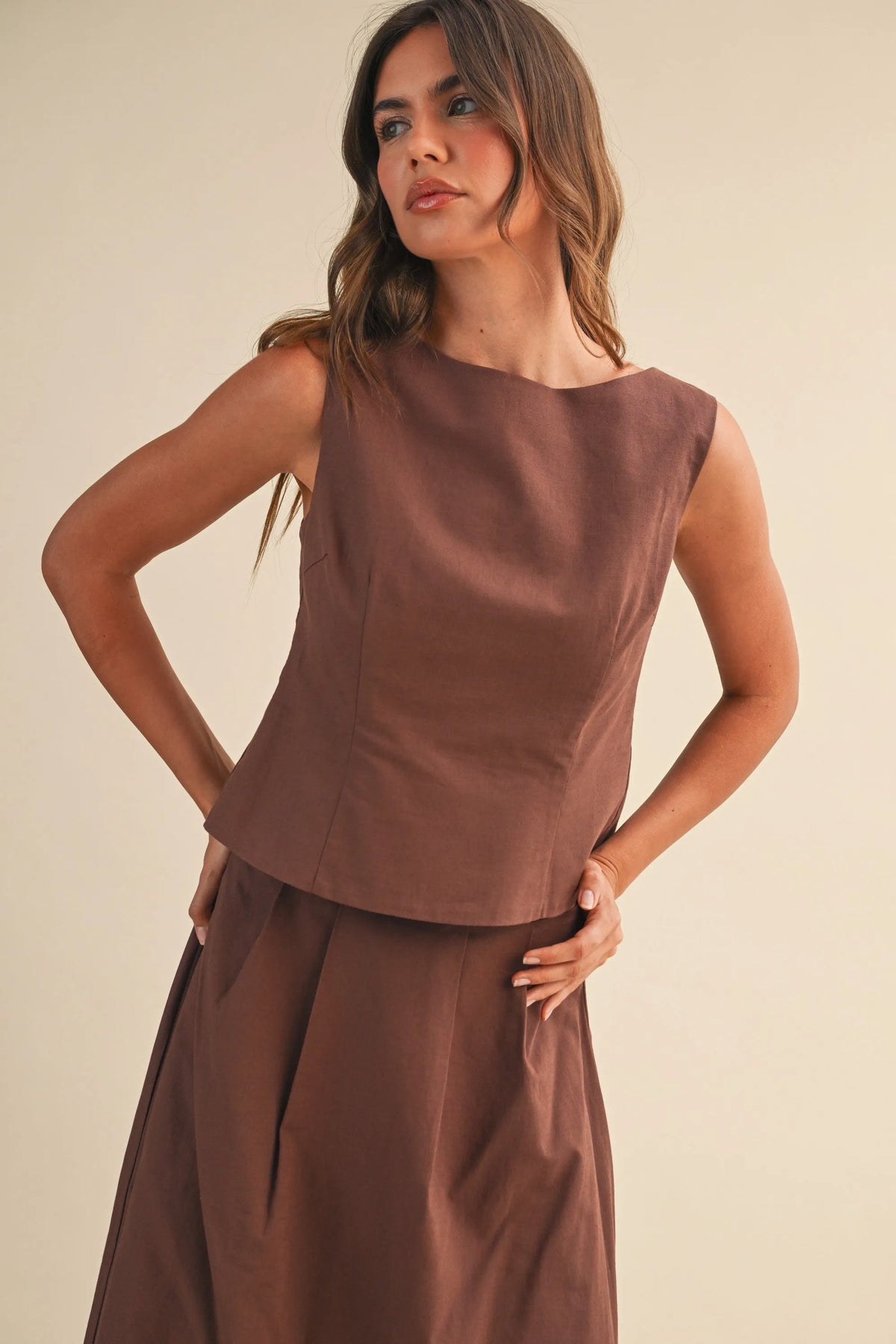 A sleek brown linen sleeveless peplum top with structured bodice ideal for stylish summer wear