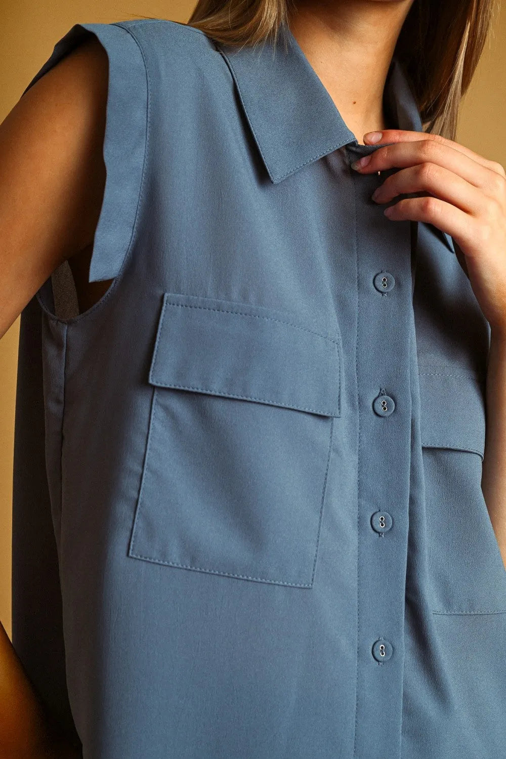 A sleeveless blue chiffon blouse with collar front pocket button design perfect for stylish summer wear