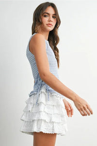 A sleeveless checkered ladder lace blouse in blue and white paired with a ruffled eyelet lace skirt