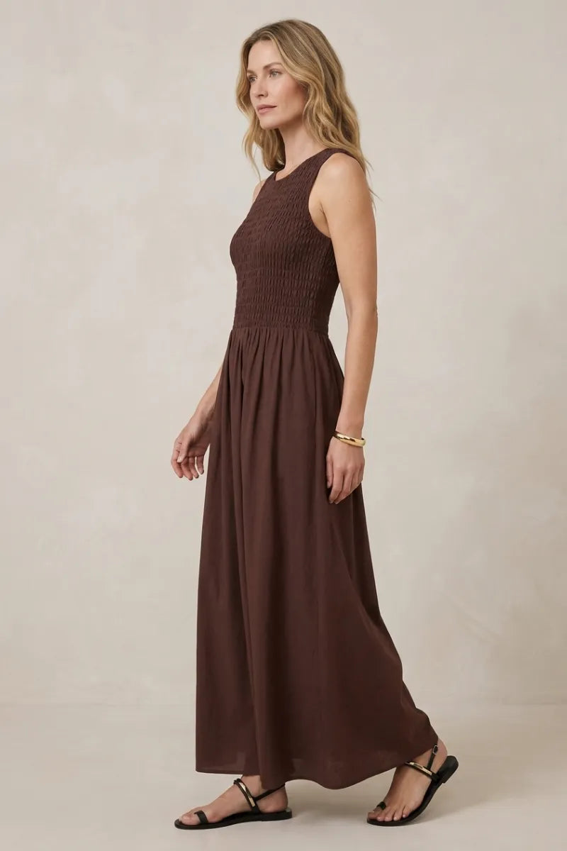A flowing sleeveless brown juniper smocked maxi dress made of soft fabric with a smocked bodice for elegant wear